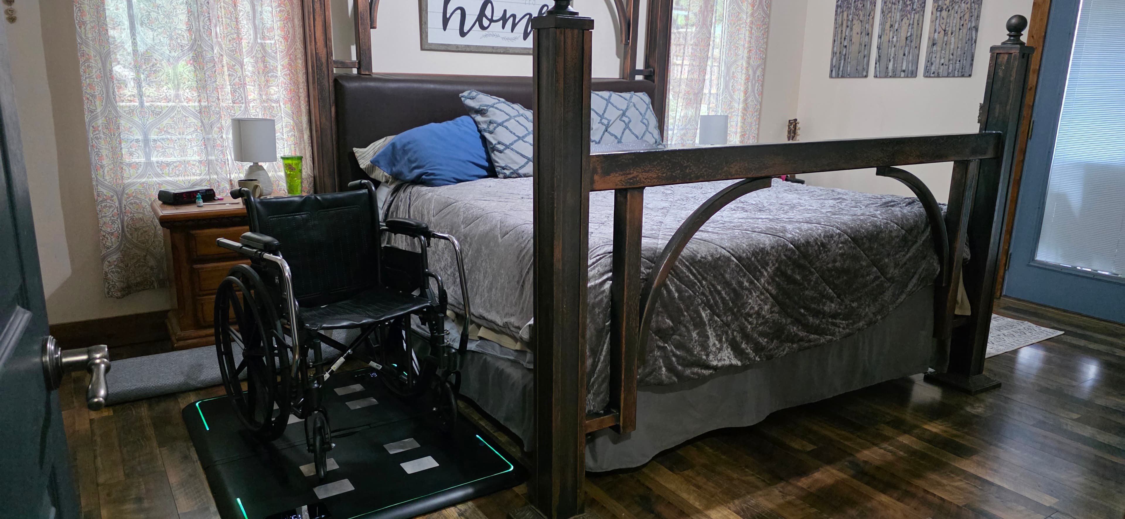 Wheelchair user positioned on Fold beside a bed at home