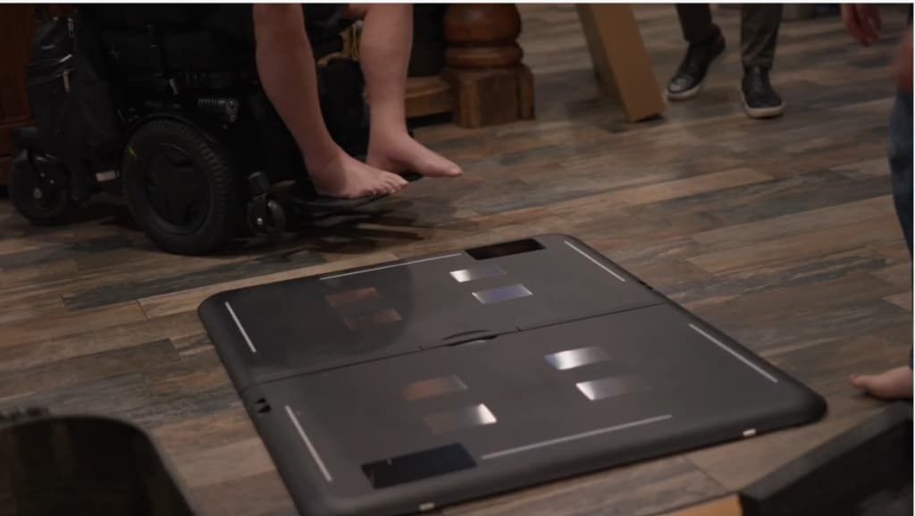 Fold fully open and flat on a hard wood floor at home, with a wheelchair alongside, ready to use.